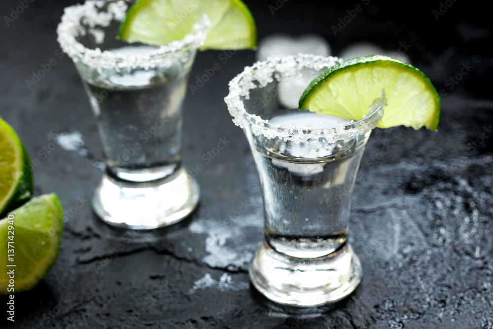 Alcohol shots with lime and salt on black background