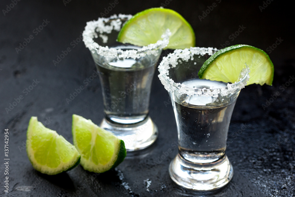 Alcohol shots with lime and salt on black background