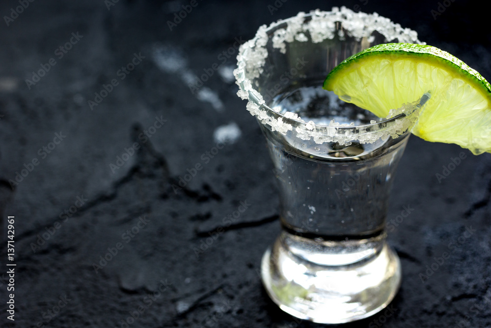 Alcohol shots with lime and salt on black background