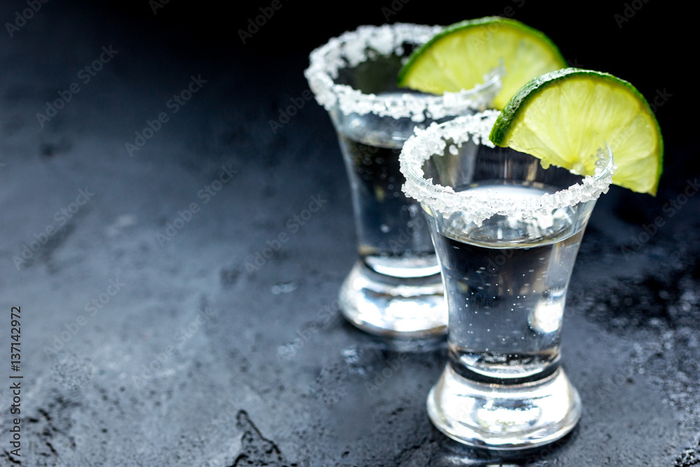 Alcohol shots with lime and salt on black background