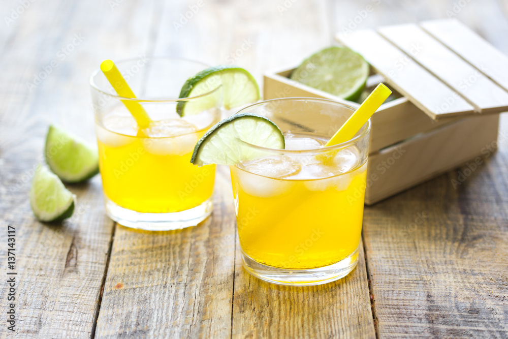 Sweet cocktails with lime and ice cubes on wooden tabel