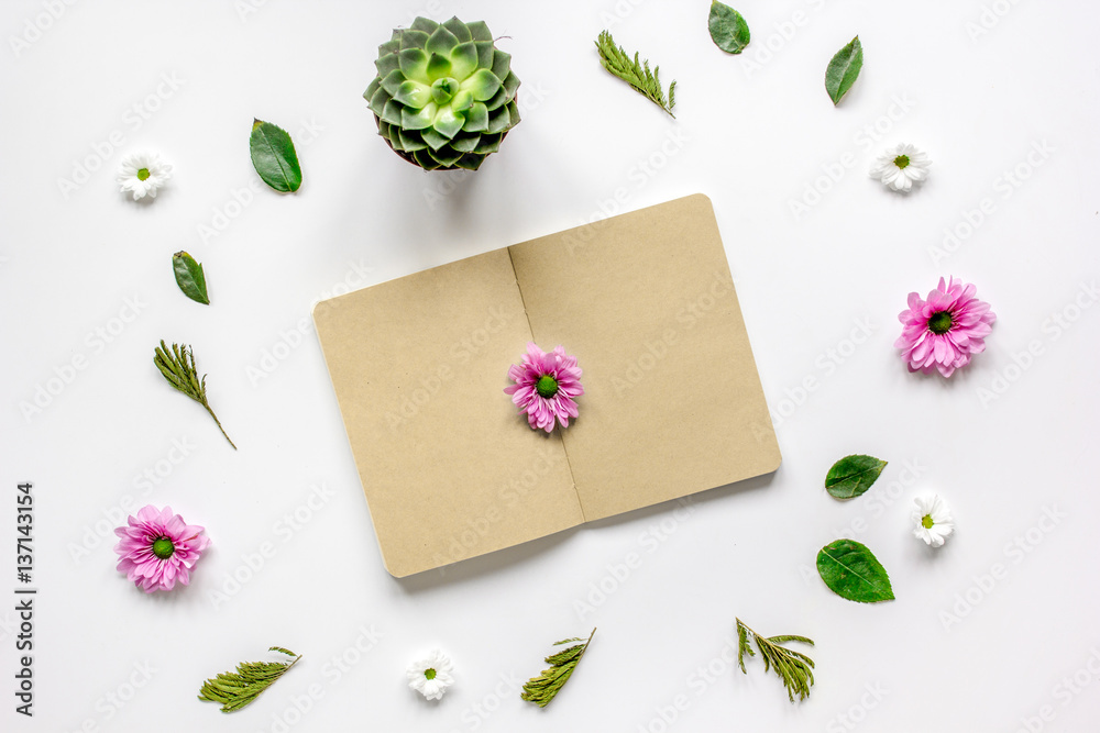 Notebook with flower petals on white table background top view mock-up