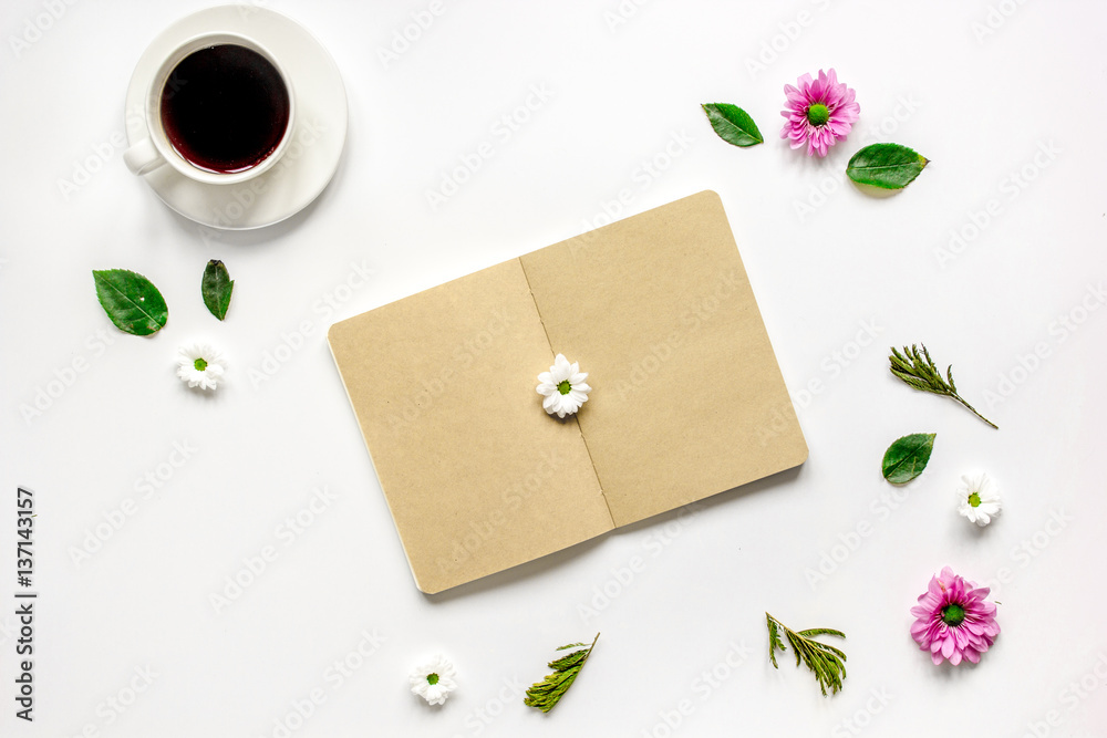 Coffee cup with flower petals and notebook top view mock-up