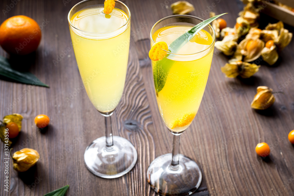 cocktail with physalis in glass on wooden background