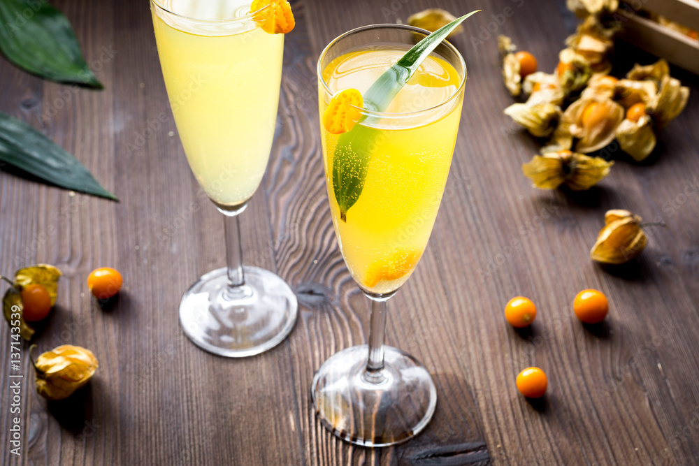 cocktail with physalis in glass on wooden background