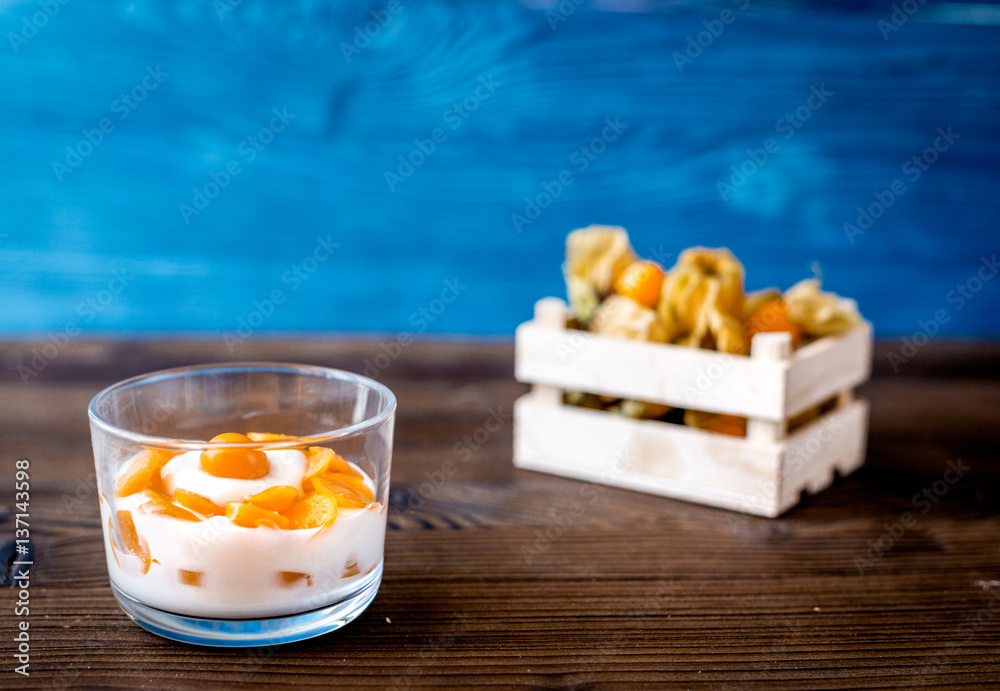 yogurt with physalis on wooden background