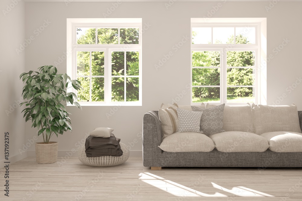 White room with sofa and green landscape in window. Scandinavian interior design