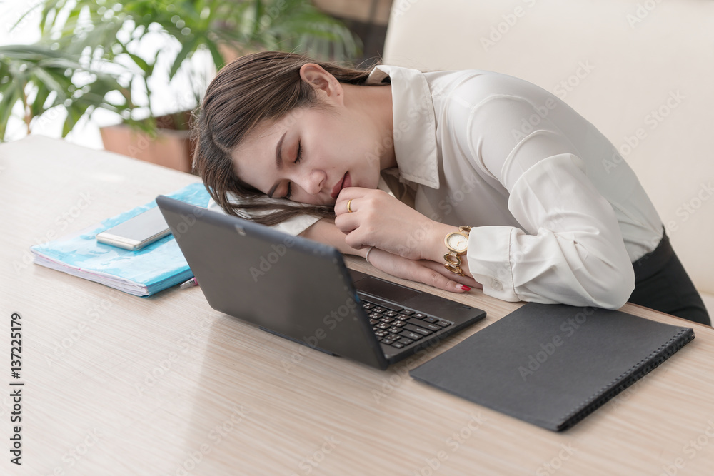 Business young asian woman sleeping on laptop during work