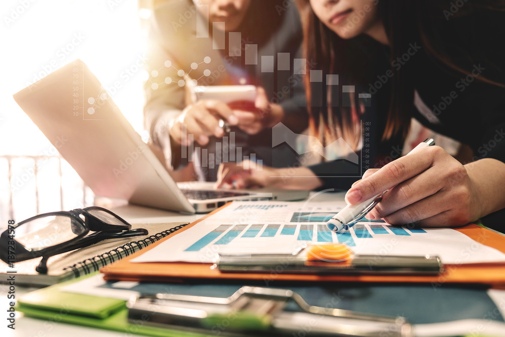 businessman documents on office table with smart phone and laptop and two colleagues discussing data