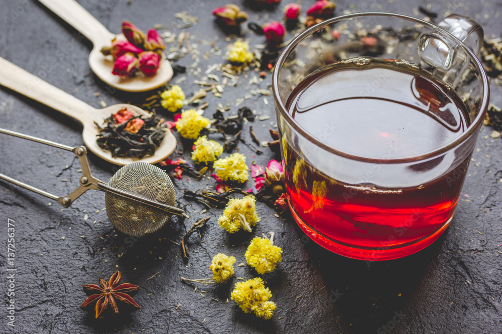 Teacup and herbs on grey background