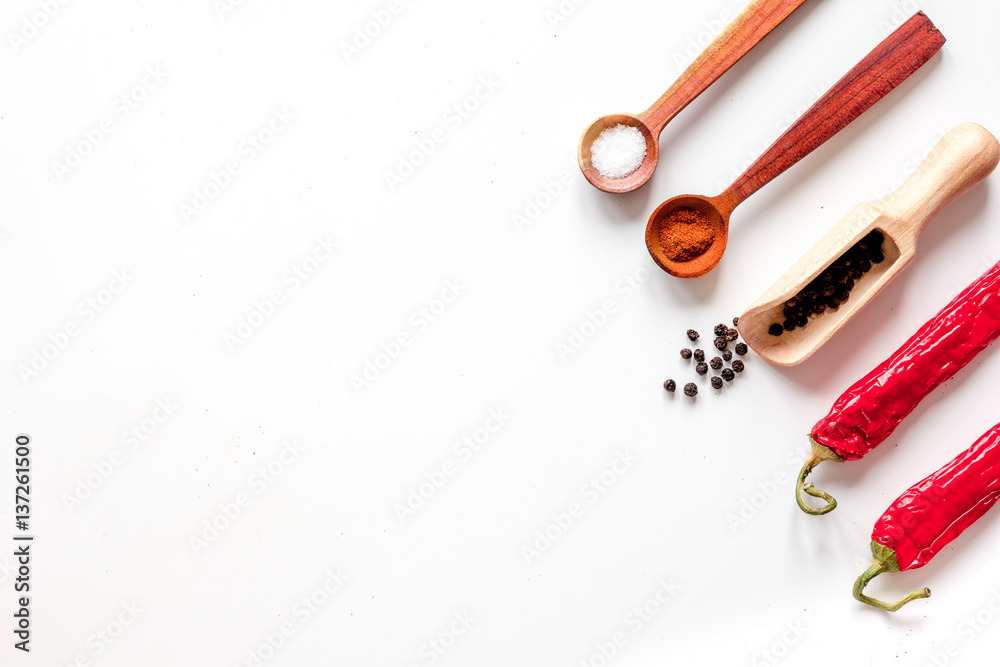 spices in wooden spoon on white background top view