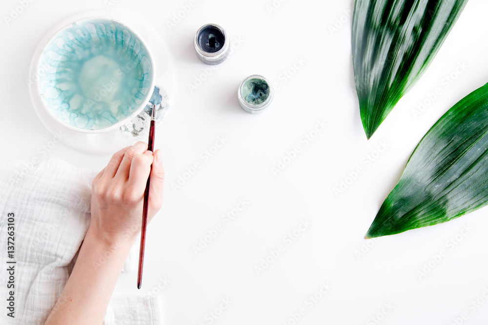 painted ceramic cup on white background top view