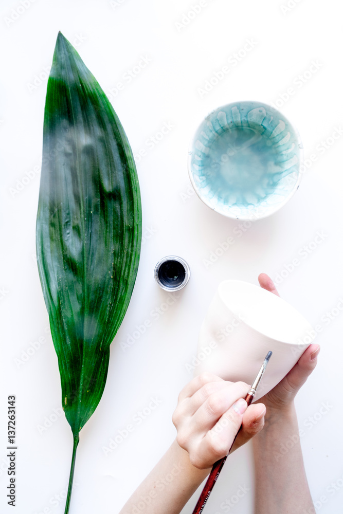 painted ceramic cup on white background top view