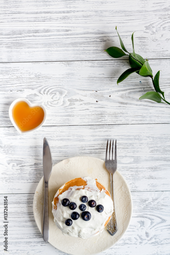 Breakfast concept with flowers on wooden background top view