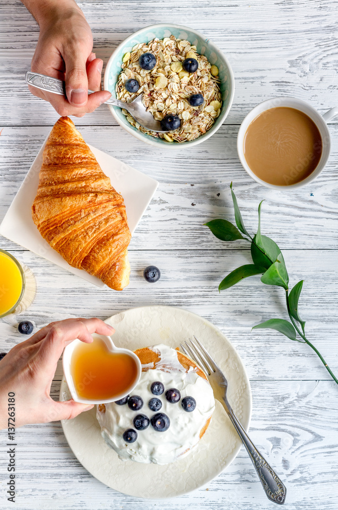 Breakfast concept with flowers on wooden background top view