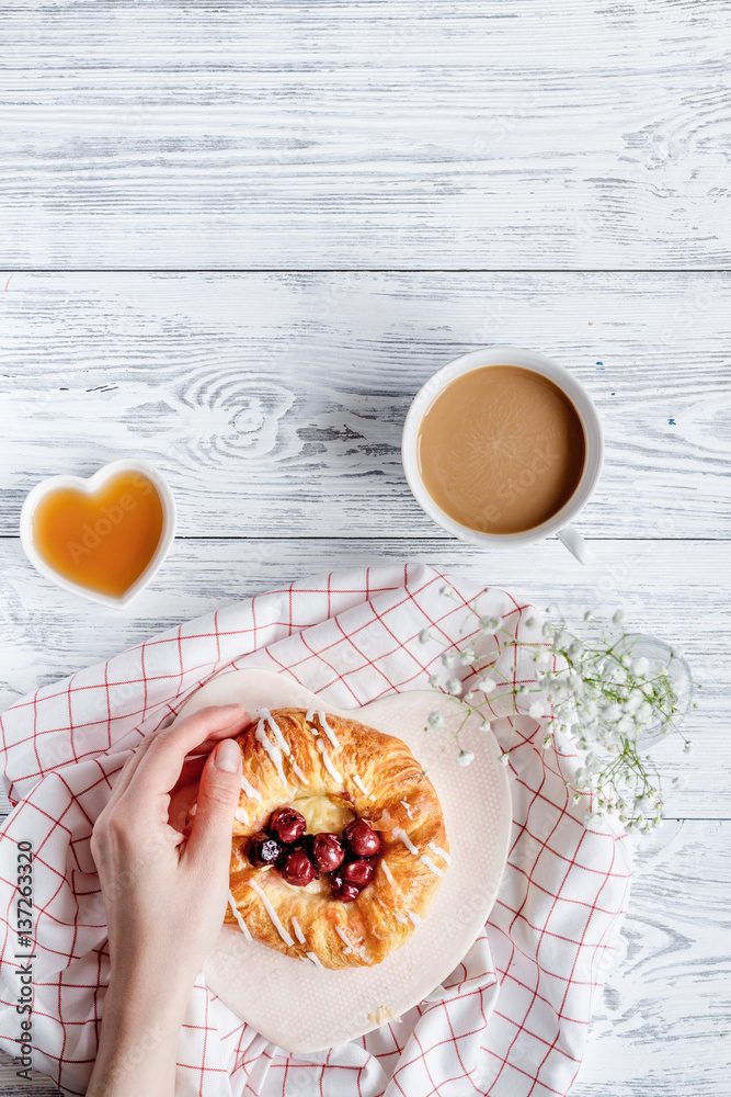 Breakfast concept with flowers on wooden background top view