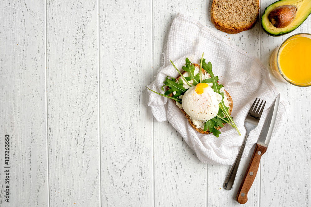 sandwich with poached eggs on wooden background top view mockup