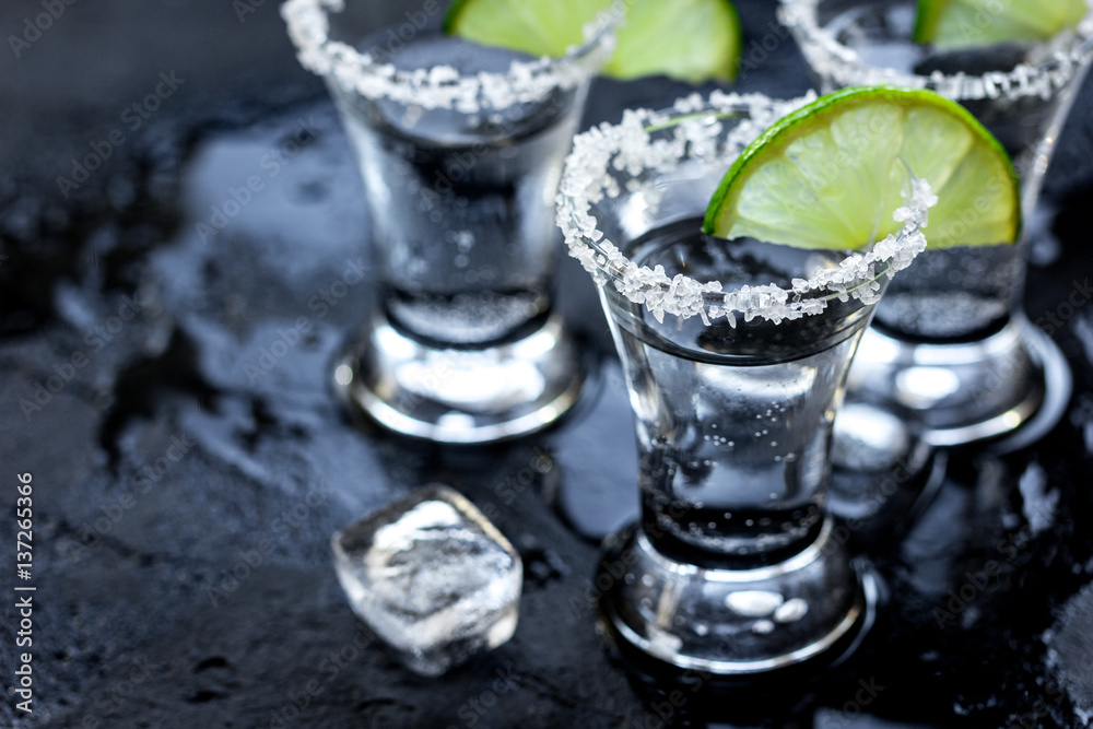 Alcohol party with tequila, ice and salt on black background