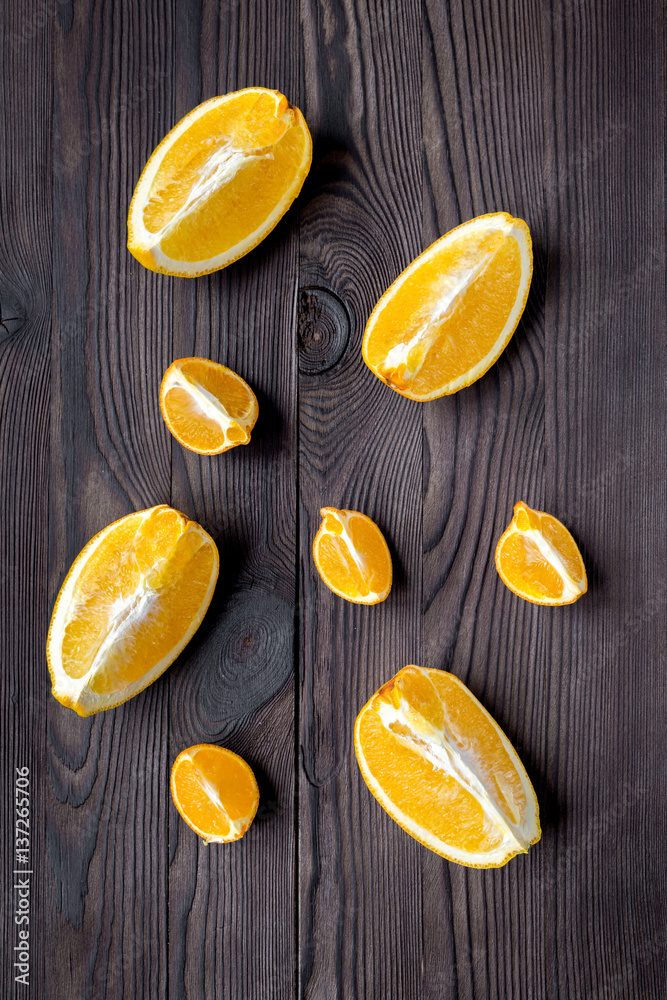 sliced oranges for lunch on dark background top view pattern