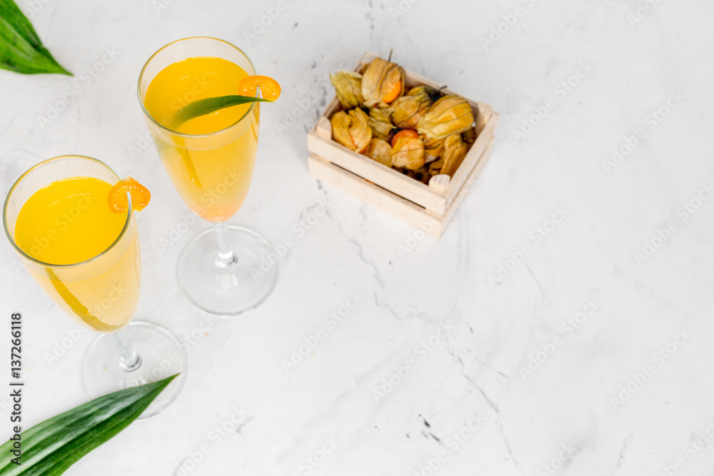 cocktail with physalis in glass on stone background