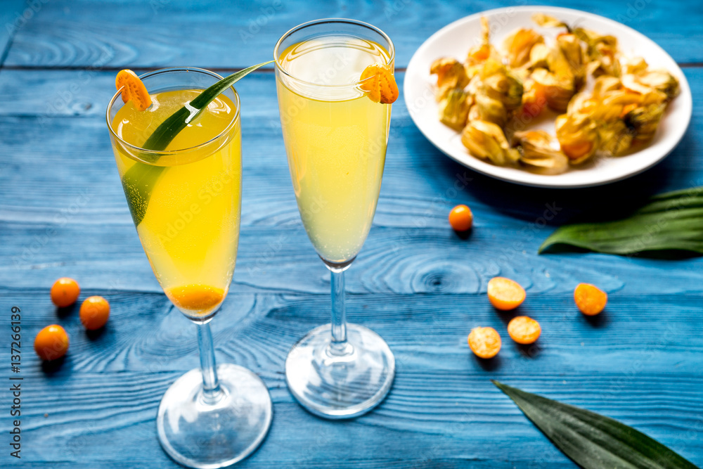 cocktail with physalis in glass on wooden background