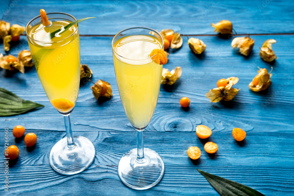 cocktail with physalis in glass on wooden background