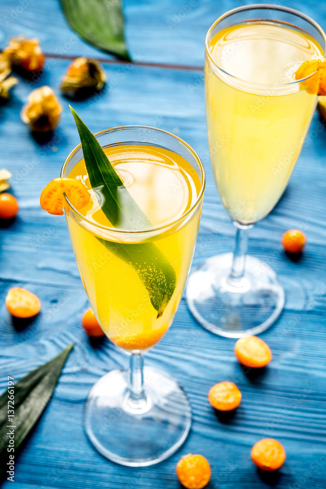 cocktail with physalis in glass on wooden background