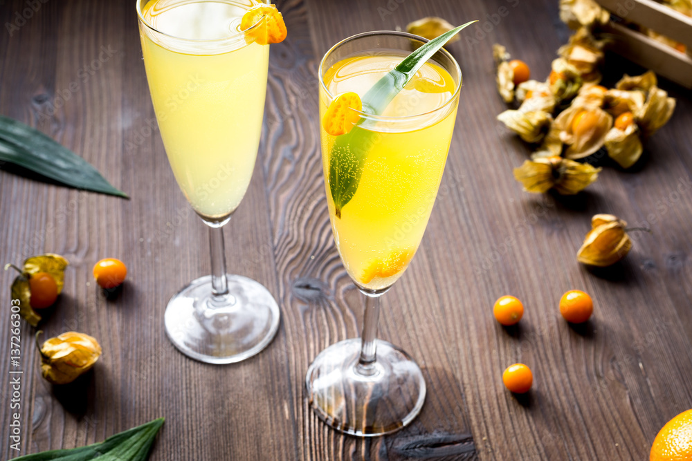 cocktail with physalis in glass on wooden background