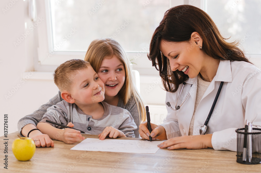 Beautiful female doctor playing with kids at doctors. Doctor isnt scary.