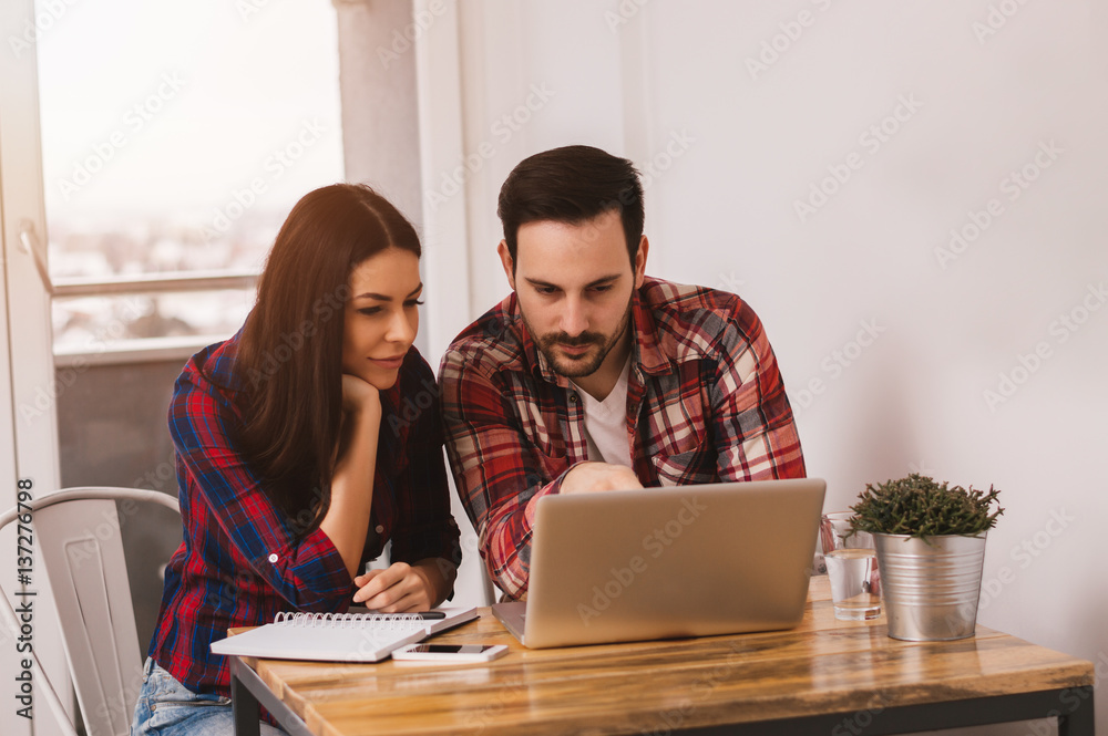 Young couple working together on laptop at home