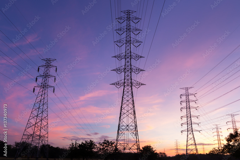 Silhouette high voltage electricity pylon on sunrise background