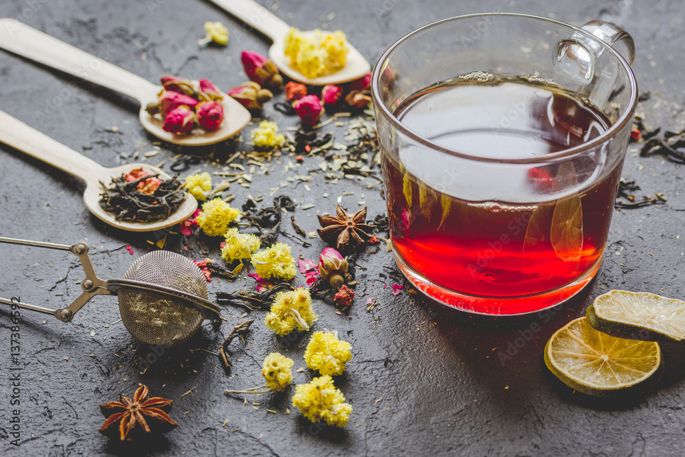 Teacup and herbs on grey background