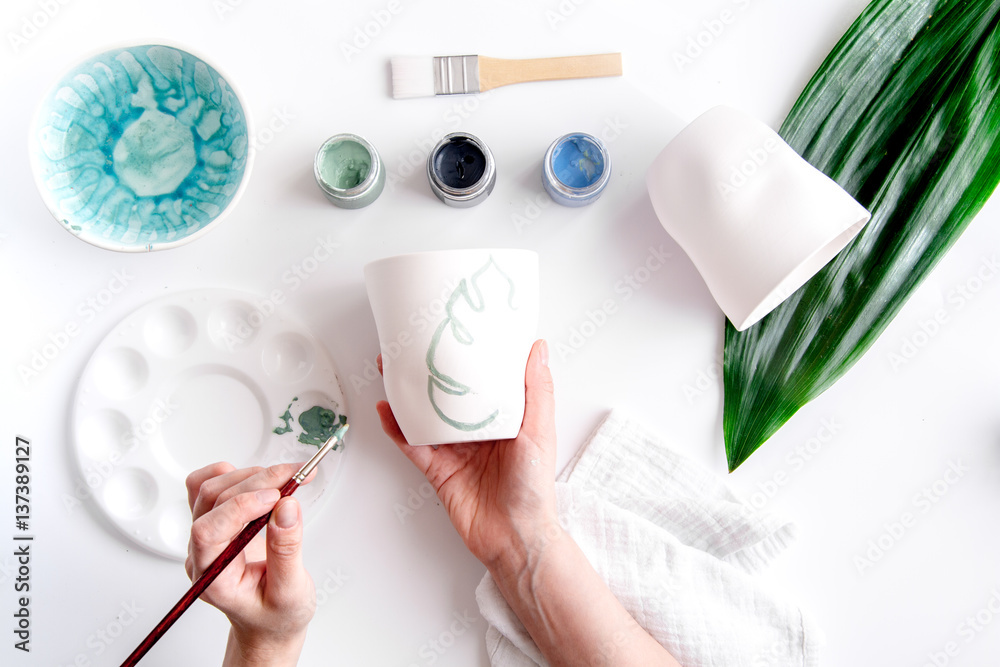 painted ceramic cup on white background top view