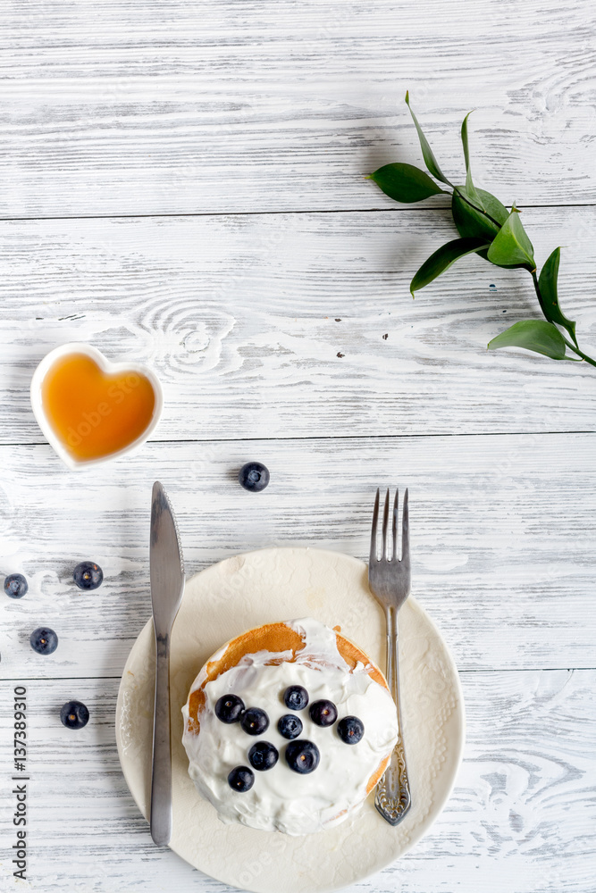 Breakfast concept with flowers on wooden background top view