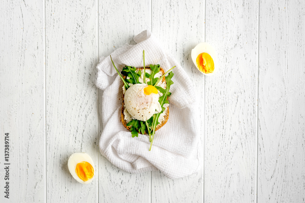 sandwich with poached eggs on wooden background top view mockup