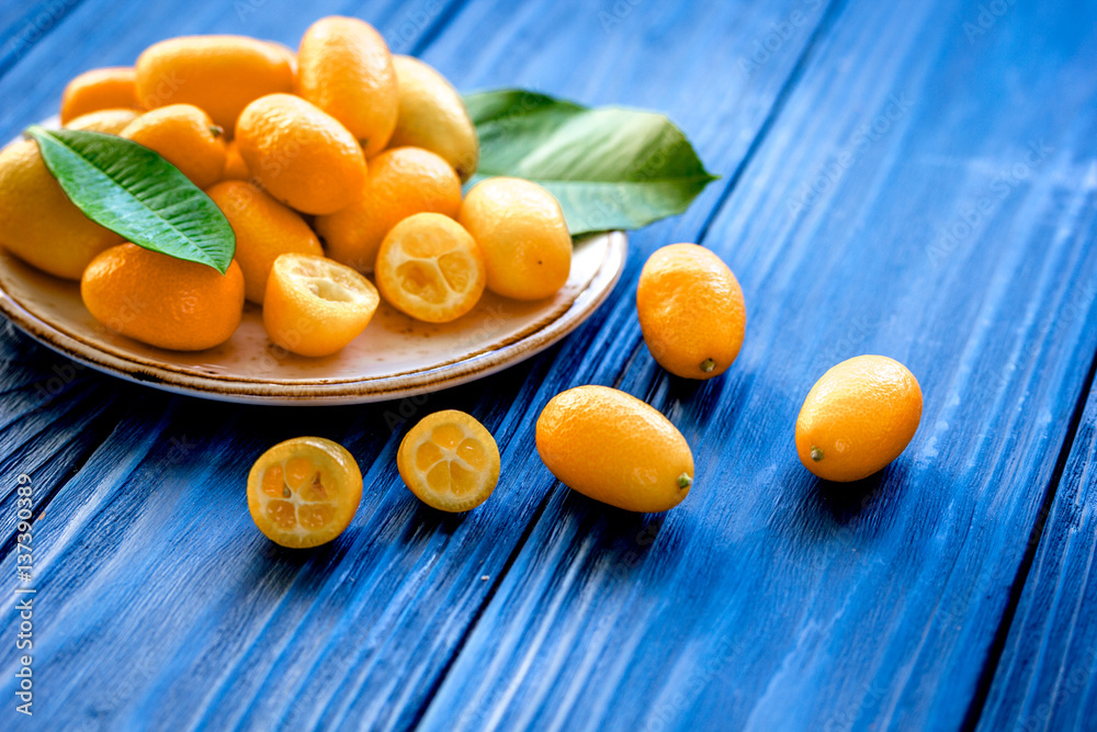 kumquat on plate at wooden table