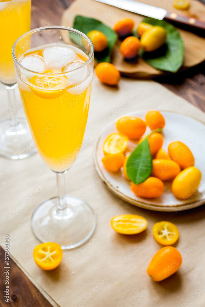 cocktail with kumquat on wooden background