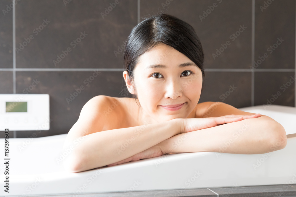 attractive asian woman relaxing in bathtub