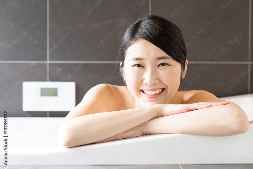 attractive asian woman relaxing in bathtub