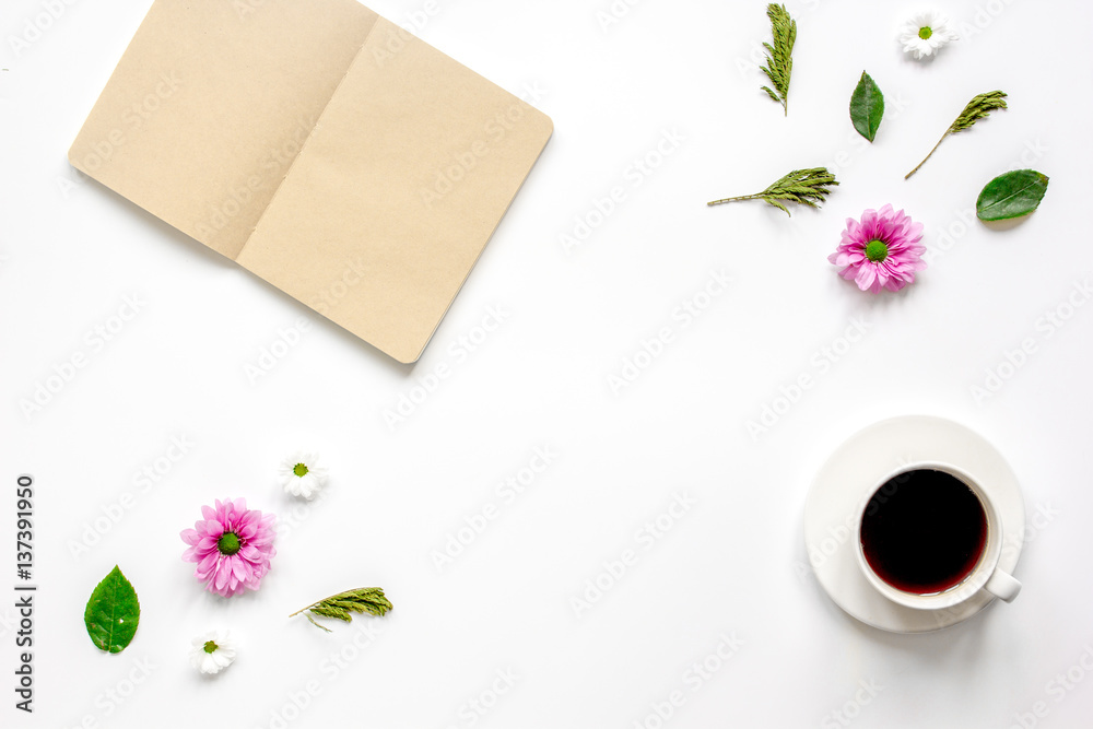 Petals, cup and copybook on table background top view mock up