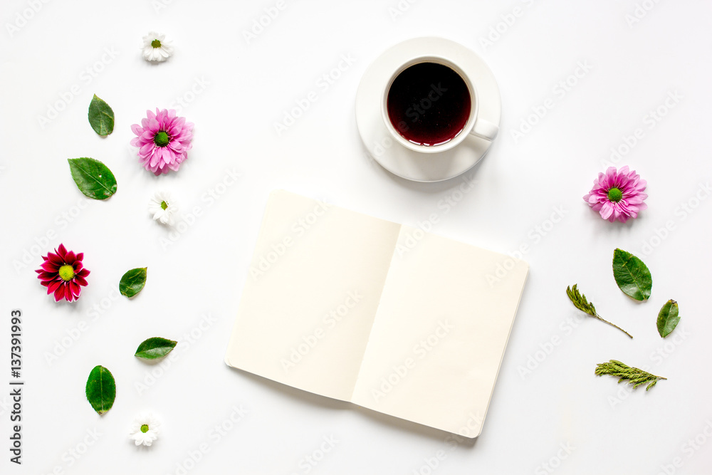 Coffee cup with flower petals and notebook top view mock-up