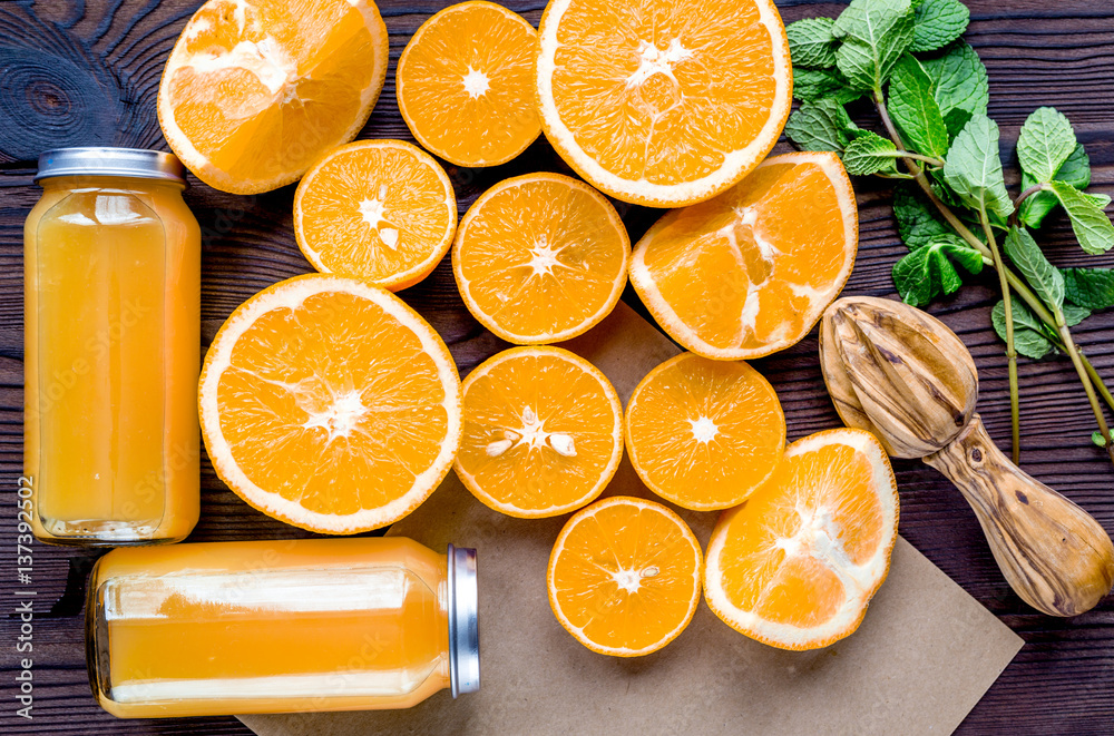 Orange juice in bottle with slices and mint on table top view