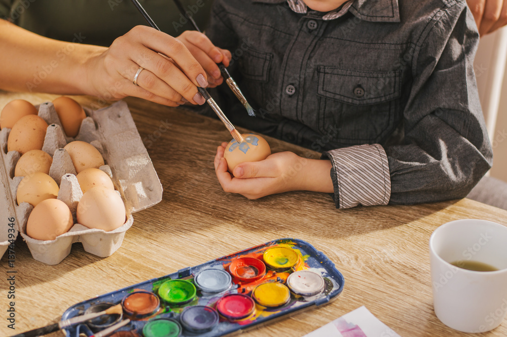 Mother and son painting eggs for Easter