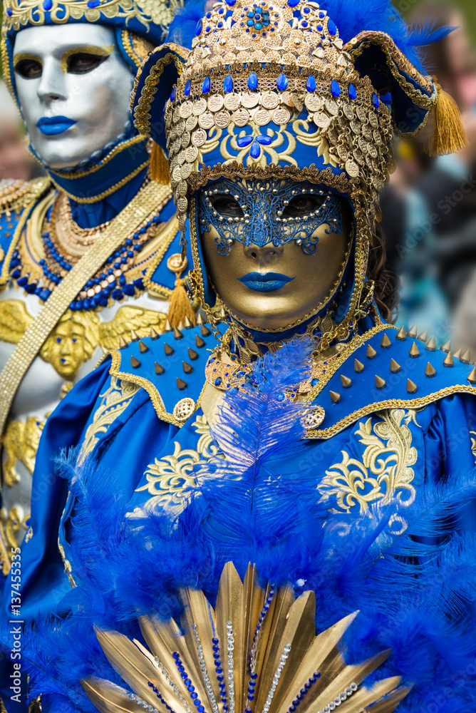 Masques de venise et costumes de carnaval. Ton bleu et or. Masque doré. Regard triste.