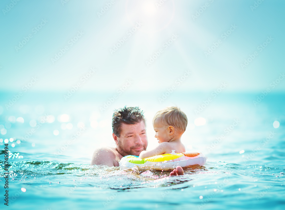 Father and son swimming at the sea