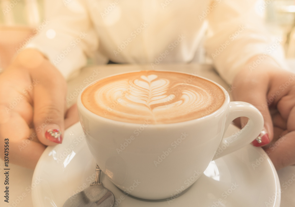 Closeup of woman holding warm latte hot cup of coffee