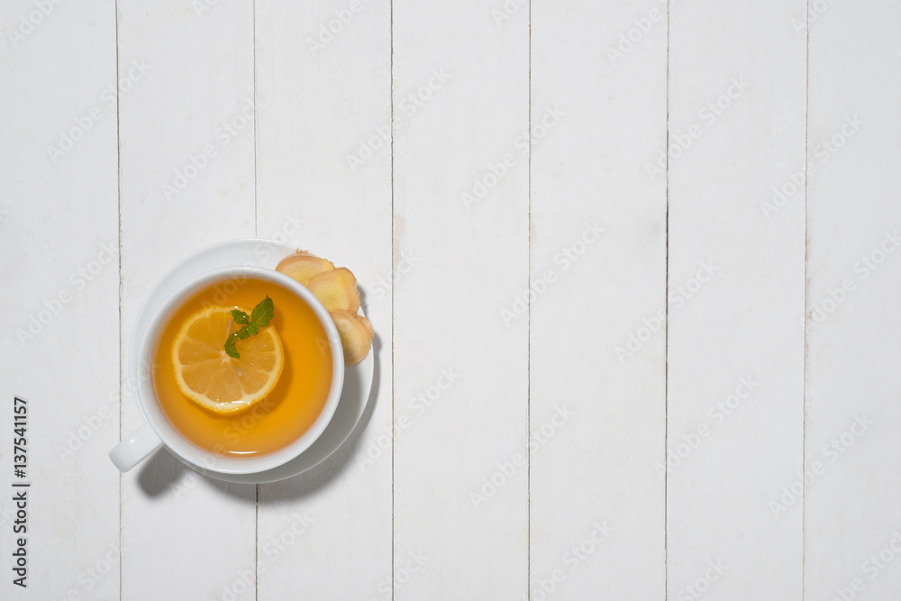 Cup of Ginger Tea with Lemon and Honey on a White Wooden Background.