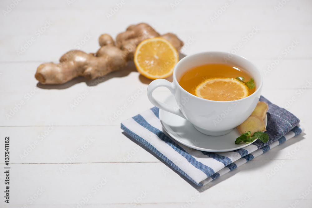 Cup of Ginger Tea with Lemon and Honey on a White Wooden Background.