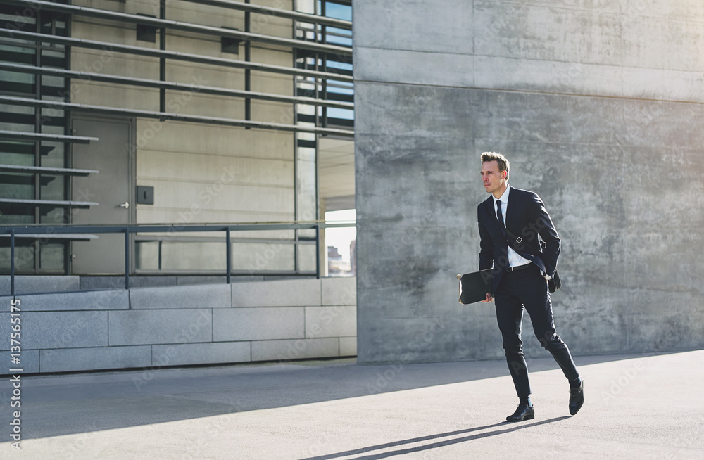 Male in dark suit rushing down street