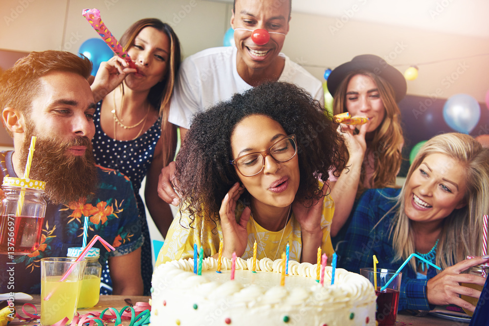 Happy woman blowing candles on cake